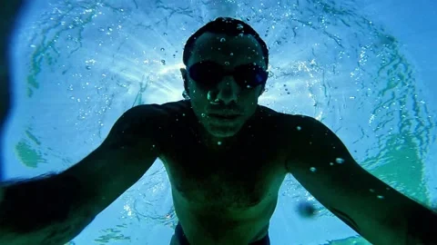 Slow-motion of a man who free-dives into the sea and begins swimming underwater Stock Footage 339055740