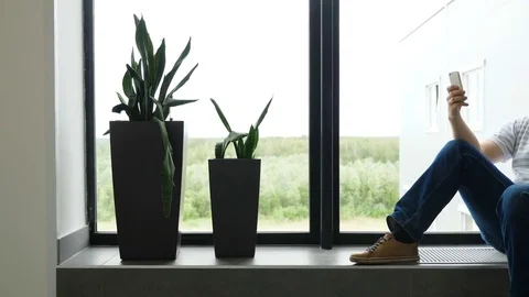 Slow motion Man writes an SMS and looks out the airport window. The guy is Stock Footage 81561986