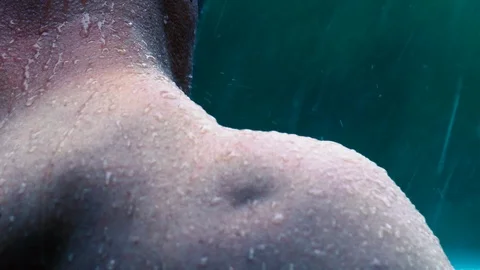 Slow motion: A man's bare shoulders are pelted by a rainstorm as he boxes Stock Footage 93161494