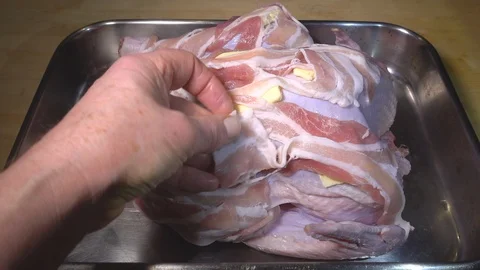 Slow motion – Man’s hand arranging butter and bacon on an uncooked turkey. Stock-Footage 100282621