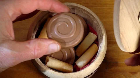 Slow motion – Man’s hand choosing a chocolate biscuit from a small barrel. Stock Footage 103147052
