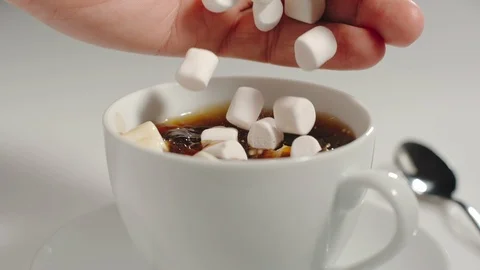 SLOW MOTION Mans hand putting marshmallow into a cup of coffee Stock Footage 101622287