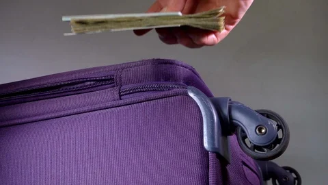 Slow motion - Man’s hand putting passport, currency and bank card on suitcase. Video stock 104598101