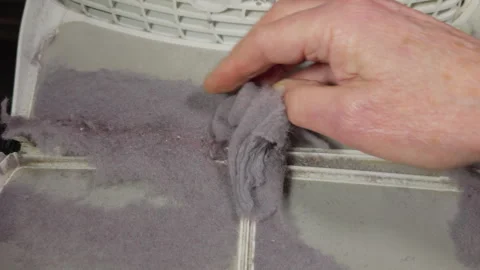 Slow motion of a man’s hand removing lint fluff from a tumble dryer filter. Stock-Footage 295774793