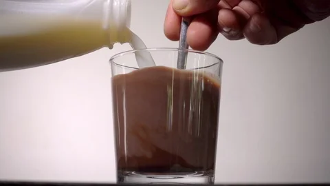 Slow motion: Man’s hand stirring a chocolate milk drink. Video stock 89717952