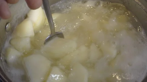 Slow motion – Man’s hand stirring boiled potatoes in a pan. Video stock 104106802