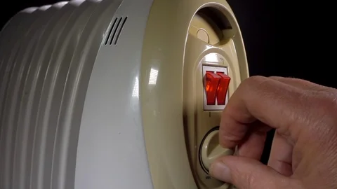 Slow motion - Man’s hand turning on a small electric heater. Stock-Footage 110295061