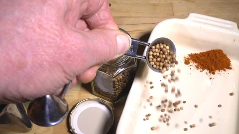 Slow motion – Man’s hand using a measuring spoon with spices and dish. Video stock 102885528
