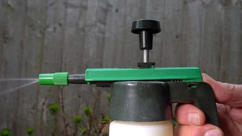 Slow motion – Man’s hand using a yard / garden spray gun. Video stock 104244578