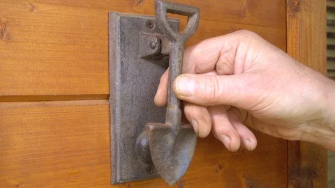Slow motion – Man’s hand using the knocker on a wood cabin wall. Stock Footage 107206894