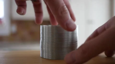 Slow motion of mans hands play with a slinky Video stock 58851569