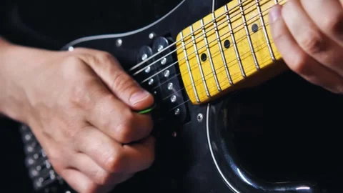 Slow motion of a man's hands playing a string pulling solo on a black electric Video stock 277873557