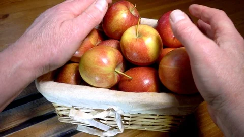 Slow motion –  Man's hands putting apples into a small wicker basket. 스톡 동영상 101642250