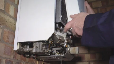 Slow motion – Man’s hands removing the front cover of a domestic boiler. Stock Footage 100751665