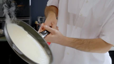 Slow-motion of a man's hands shaking a hot pan with thin pancakes, crepes. Stock Footage 283006678