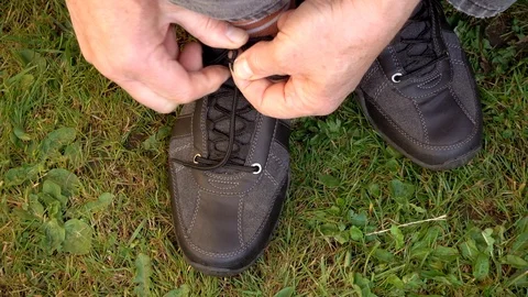 Slow motion: Man’s hands tying a shoelace. Video stock 89863230