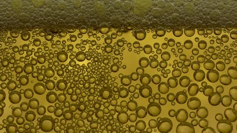 Slow motion, many air bubbles and foam moving slowly from cold yellow beer Stock Footage 79579333