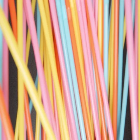 SLOW MOTION: Many colour tubes fall on a black table Vídeos de archivo 69359072