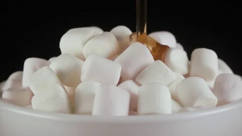 Slow motion. Marshmallow pour syrup over a black background Stock Footage 75312980