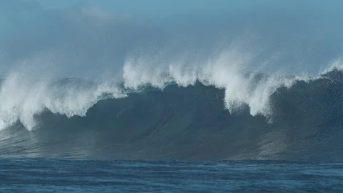 SLOW MOTION: Massive emerald ocean swell breaks and sends water droplets flying. Stock Footage 87488501