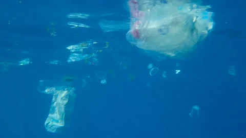 Slow motion, Massive plastic and other debris slowly drifts under surface of the Stock Footage 142932190