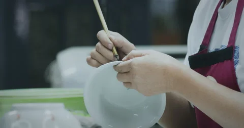 Slow motion, master painter drawing picture on ceramic bowl Stock Footage 203233732