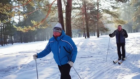 Slow motion. Mature couple skiing in the woods in winter time. Stock Footage 80201955