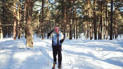 Slow motion. Mature man skiing in the woods in winter time. Stock Footage 80202372