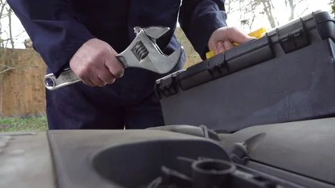 Slow motion –  Mechanic lifting a toolbox and wrench under car bonnet / hood. Video stock 101739835