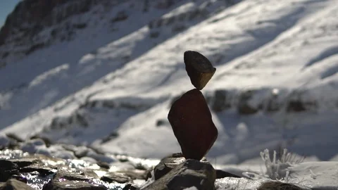 Slow Motion Meditative Stone Stack next to River on Snowy Mountain Stock Footage 92332372