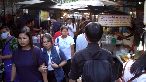 A slow motion medium follow shot of a man walking through a market in Bangkok Stock Footage 127842432