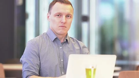 A slow-motion medium plan of a young businessman with a laptop. A smiling man is Stock Footage 201380643