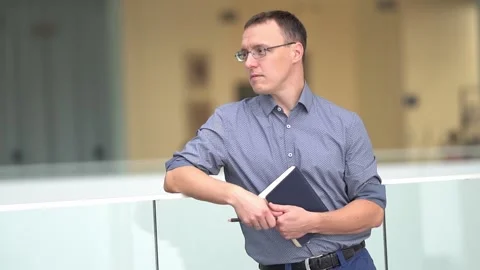 A slow-motion medium plan of a young businessman with a notebook in his hands. A Stock Footage 201956197