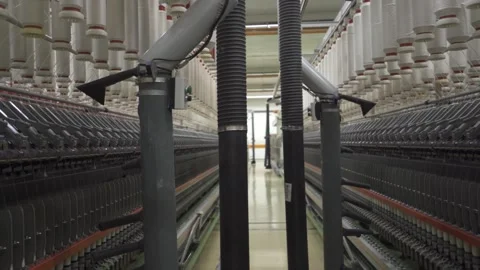 Slow motion medium shot of blowers passing through a spinning mill corridor Stock Footage 257762553