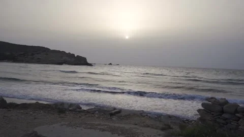 Slow motion medium shot of sunset at a beach on a moody day Stock Footage 257949514