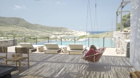 Slow motion medium shot of a swing by a pool Stock Footage 257950163