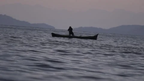 Slow Motion Medium Shot of a Traditional Fisherman in a Canoe at Dawn in Paraty Stock Footage 320635007