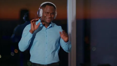Slow-motion medium shot of a young dark-skinned man dancing in headphones, a Видео 263394398