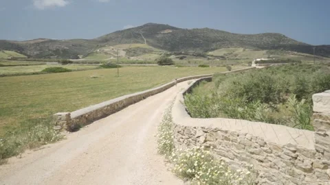 Slow motion medium wide shot of a country road on a sunny day Stock Footage 257949937