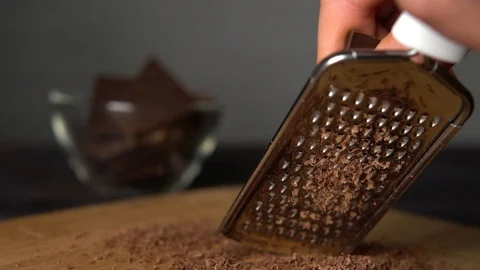 Slow motion men hand grating dark chocolate Stock Footage 100407456