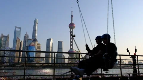 Slow Motion of men playing on the swing in China's Shanghai Stock Footage 301983381
