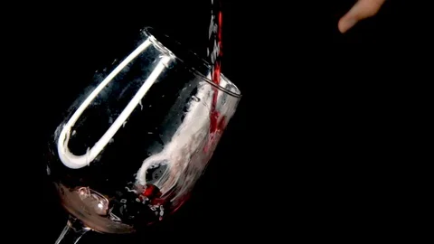Slow motion messy red wine pour into a tilted wine glass Stock Footage 94356577
