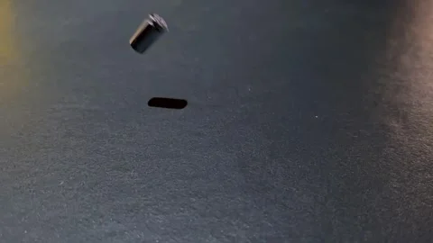 Slow Motion on a Metal Chrome Empty Bullet Cartridge with Shadow Falling Down Stock Footage 257028787