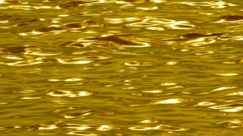 Slow motion metallic looking water. Silky smooth waves. Gold tint. Stock Footage 79517217