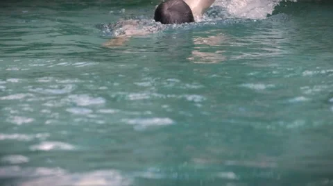 Slow motion of a middle aged man swimming freestyle towards the camera Stock Footage 58931823