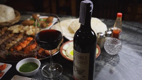 Slow-motion of middle eastern dishes served on a table with wine Stock Footage 129928057