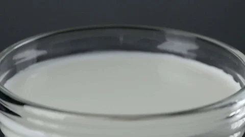 Slow-motion milk dropping and splashing Stock Footage 78483043