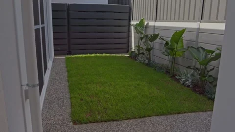 Slow Motion Minimal Backyard Green Lawn Plants Rainwater Tanks Retaining Wall Stock Footage 304092026