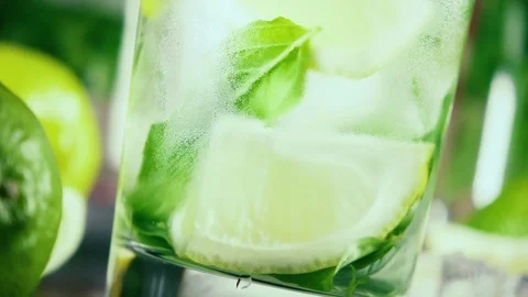 Slow motion in a misted glass with ice and lemon pour water Stock Footage 92319146