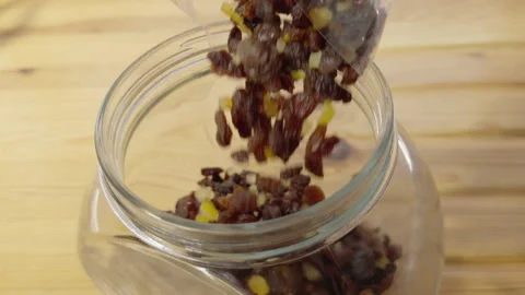 Slow motion of mixed dried fruit pouring into a glass storage jar. Vídeos de archivo 295861070